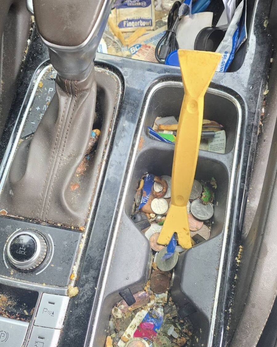 Center console and cup holders packed with coins, wrappers and ground-in debris before cleaning