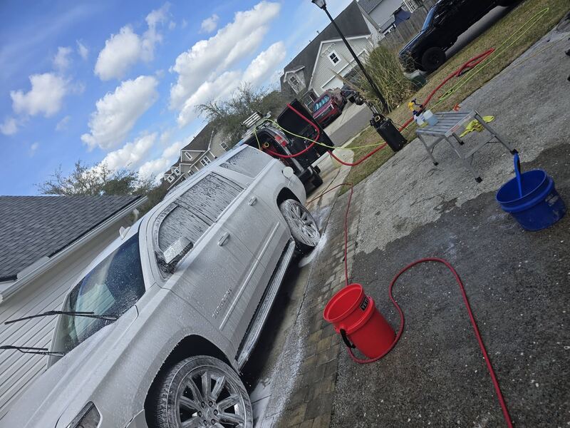 Rinsing down a full-size SUV on the driveway
